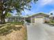 A single-story home features an attached garage, stone accents, and a well-manicured lawn at 5511 Drinkard Dr, New Port Richey, FL 34653