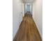 Hallway features hardwood floors and white doors leading to various rooms at 5511 Drinkard Dr, New Port Richey, FL 34653
