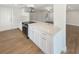 Bright kitchen features white cabinets, stainless appliances, and stone countertops at 5511 Drinkard Dr, New Port Richey, FL 34653