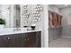 Stylish bathroom vanity with decorative mirror and lighting fixture, leading into a walk-in closet at 14375 Hammock Oak St, Parrish, FL 34219