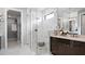 Luxurious bathroom features a glass-enclosed shower with marble tiling and a sleek vanity with modern fixtures at 14375 Hammock Oak St, Parrish, FL 34219