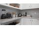 Kitchenette featuring sleek countertops, white cabinets, and stainless appliances; perfect for cooking and storage at 14375 Hammock Oak St, Parrish, FL 34219