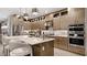 Elegant kitchen featuring modern appliances, stylish lighting, a center island with seating, and sleek cabinetry at 14375 Hammock Oak St, Parrish, FL 34219