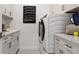 Bright laundry room with modern appliances, ample storage and a convenient scheduling board at 14375 Hammock Oak St, Parrish, FL 34219