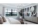 Elegant main bedroom with large windows, modern chandelier, textured walls, and refined decor at 14375 Hammock Oak St, Parrish, FL 34219