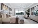 Beautiful main bedroom featuring large windows, a modern chandelier, textured accent wall, and stylish decor at 14375 Hammock Oak St, Parrish, FL 34219