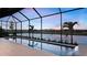 Stunning screened-in pool area with a serene waterfront view and lush landscaping at 14375 Hammock Oak St, Parrish, FL 34219