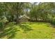 Secluded back yard with lush green grass and mature trees, creating a private and tranquil oasis at 2002 Culpepper Dr, Brandon, FL 33511