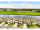 Beautiful aerial view of homes with manicured lawns, a pond, and a scenic backdrop of trees and power lines at 4704 Wild Senna Blvd, Tampa, FL 33619