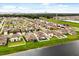 Aerial view of homes with green lawns, and water feature surrounded by lush landscapes and cityscape in the distance at 4704 Wild Senna Blvd, Tampa, FL 33619
