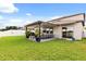Relaxing covered patio with outdoor seating, plants, and a well-maintained lawn, perfect for outdoor enjoyment at 4704 Wild Senna Blvd, Tampa, FL 33619