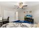 Comfortable bedroom featuring ocean themed decor, a dedicated work space and a ceiling fan at 4704 Wild Senna Blvd, Tampa, FL 33619