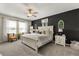 Spacious bedroom boasts a dark accent wall, neutral decor, and an abundance of natural light from the windows at 4704 Wild Senna Blvd, Tampa, FL 33619