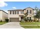 Home with two-car garage, manicured lawn, and trimmed bushes showcasing curb appeal at 4704 Wild Senna Blvd, Tampa, FL 33619
