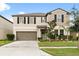 Charming two-story home with a two-car garage and well-manicured front yard and a light green door at 4704 Wild Senna Blvd, Tampa, FL 33619