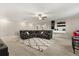 Spacious living room with a large black sectional, patterned rug, ceiling fan, and a bar area at 4704 Wild Senna Blvd, Tampa, FL 33619