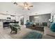 Open concept living room with kitchen, gray sectional, patterned chair, and modern decor, creating a welcoming space at 4704 Wild Senna Blvd, Tampa, FL 33619