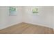 Empty bedroom featuring wood-look floors and two windows, providing lots of natural light at 6208 S Harold Ave, Tampa, FL 33616