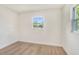 Empty bedroom with window, new flooring, and white walls at 6208 S Harold Ave, Tampa, FL 33616