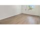 Bright empty room featuring hardwood floors and freshly painted white walls at 6208 S Harold Ave, Tampa, FL 33616