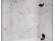 Close-up of the shower, showcasing elegant marble tiling and matte black fixtures at 6208 S Harold Ave, Tampa, FL 33616