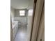Bright bathroom with a white vanity, toilet, and white tile floor at 7240 Rosarian Dr, Port Richey, FL 34668