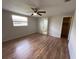 Comfortable bedroom with laminate flooring, ceiling fan, and adjacent bathroom at 7240 Rosarian Dr, Port Richey, FL 34668