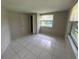 A cozy bedroom featuring tile floors, a window, and a convenient closet at 7240 Rosarian Dr, Port Richey, FL 34668