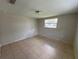 A serene bedroom with tile floors, a window offering natural light at 7240 Rosarian Dr, Port Richey, FL 34668