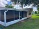 View of screened-in back patio and landscaped backyard at 7240 Rosarian Dr, Port Richey, FL 34668