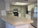 Bright kitchen with stainless steel appliances, white cabinets, and spacious breakfast bar at 7240 Rosarian Dr, Port Richey, FL 34668