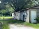 Backyard buildings and fenced area with large shade trees at 26627 Brahma Dr, Wesley Chapel, FL 33544