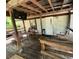 Covered porch area with chairs, a tv, and a wooden railing, creating a relaxing outdoor space at 26627 Brahma Dr, Wesley Chapel, FL 33544