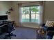 Cozy home office featuring a large window, computer desk, comfortable chair, and tasteful decor at 16650 Windmill Forge Pass, Wimauma, FL 33598