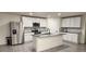 Modern kitchen boasts white cabinets, stainless steel appliances, and a granite-topped island at 16650 Windmill Forge Pass, Wimauma, FL 33598