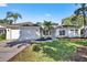 Charming one-story home featuring a manicured lawn, mature palm trees, and an attached two-car garage at 11019 Pine Lilly Pl, Lakewood Ranch, FL 34202