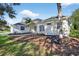 Elegant one-story home with manicured landscaping, featuring a front lawn and mature trees at 11019 Pine Lilly Pl, Lakewood Ranch, FL 34202
