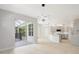 Spacious living room with sliding glass doors and view into the kitchen at 11019 Pine Lilly Pl, Lakewood Ranch, FL 34202