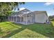 Home back exterior featuring a screened-in pool area, green grass and plenty of space for outdoor entertaining at 11019 Pine Lilly Pl, Lakewood Ranch, FL 34202