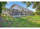 Back exterior featuring a screened-in pool area, green grass and space for outdoor entertaining at 11019 Pine Lilly Pl, Lakewood Ranch, FL 34202