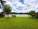 Spacious backyard with green grass, white picket fence, and views of the lake at 11124 Leland Groves Dr, Riverview, FL 33579