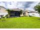 Expansive green backyard features a screened lanai, lush lawn, climbing vines, and mature landscaping at 11124 Leland Groves Dr, Riverview, FL 33579