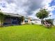 Expansive green backyard featuring a screened lanai, a lush lawn, and a waterfront view at 11124 Leland Groves Dr, Riverview, FL 33579