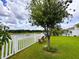 Relaxing backyard featuring green lawn, flowering trees, waterfront view, and comfortable seating at 11124 Leland Groves Dr, Riverview, FL 33579