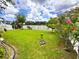 Spacious backyard with lush green grass, beautiful landscaping, and a white fence overlooking a pond at 11124 Leland Groves Dr, Riverview, FL 33579