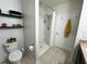 Cozy bathroom featuring a toilet with shelving and a walk-in shower with tiled floors at 11124 Leland Groves Dr, Riverview, FL 33579