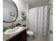 Charming bathroom featuring dark cabinets, a decorative mirror, and a shower for a stylish and functional design at 11124 Leland Groves Dr, Riverview, FL 33579