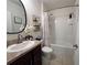 Well-appointed bathroom with dark wood cabinets, a decorative mirror, and a shower-tub combo for convenience at 11124 Leland Groves Dr, Riverview, FL 33579