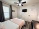 Comfortable bedroom with wood-look flooring, a ceiling fan, and a white metal bed frame, creating a relaxing space at 11124 Leland Groves Dr, Riverview, FL 33579