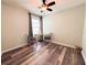 Relaxing bedroom with wood-look flooring, a window with blinds, and cozy seating area at 11124 Leland Groves Dr, Riverview, FL 33579